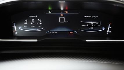 Car dashboard panel with speedometer, tachometer, odometer, fuel gauge and gear position indicator.