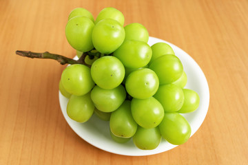 bunch of green grapes on white plate