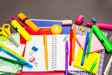 Back to school concept. School education supplies on black stone concrete background.
