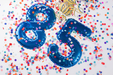 Blue number 85 with colorful confetti. 85th birthday anniversary greeting logo
