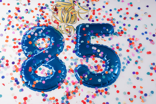 Blue number 85 with colorful confetti. 85th birthday anniversary greeting logo