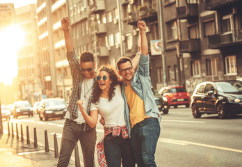 Group of friends hangout at the city street.They embrace each other and laughing.