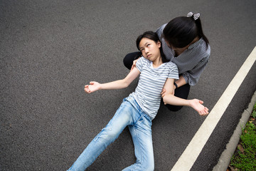 Sick child girl with epileptic seizures on street,daughter suffering from seizures,illness with epilepsy during seizure attack,asian woman or mother care of girl patient,brain,nervous system concept - obrazy, fototapety, plakaty