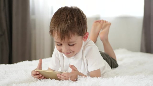 Cute little boy playing using smartphone. Applications for the development of children.