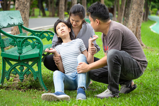 Sick child girl with epileptic seizures at park,daughter suffering from seizures,illness with epilepsy during seizure attack,asian mother,father care of girl patient,brain,nervous system concept