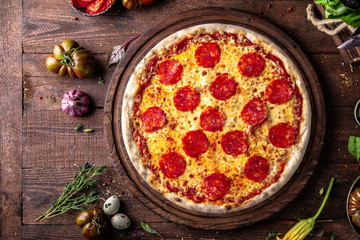 Tasty hot italian pizza Grand Pepperoni with Mozzarella, Tomato Sauce, Pepperoni on old wooden...