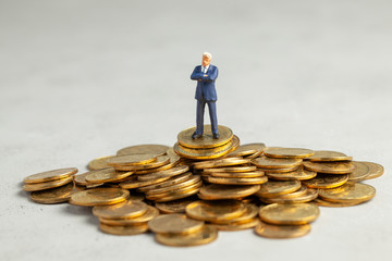 Successful businessman with big profits is standing on pile of gold coins. Successful investment of...