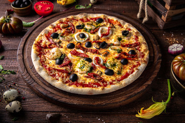 Tasty hot italian pizza Marinara with Squids, Shrimps, Olives, Mussels, Dried Tomatoes, Tomato Sauce with  on old wooden table. Pizzeria menu. Concept poster for Restaurants or pizzerias