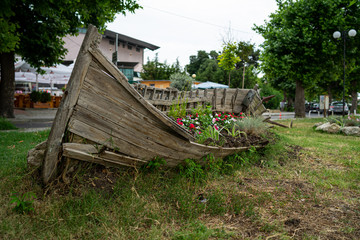 Old wooden boat as a decoration (flowerbed with flowers) on the streets of the seaside town. Pomorie. Bulgaria.