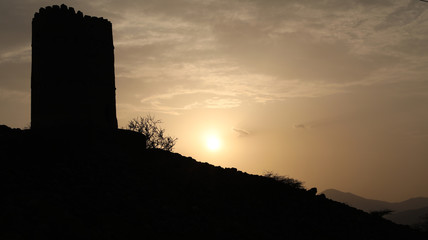 Old tower of the spectrum with sunset silhouette in the Sultanate of Oman