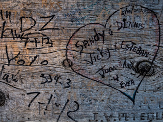 wood bank marked with names, dates and a heart