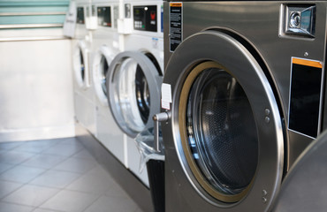 Several washing machines in public laundry.