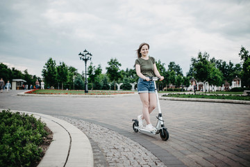 Electric scooter for a girl in the city. eco-friendly transport is an alternative to a car in the city, combating traffic congestion.