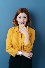 Shocked excited young woman over blue