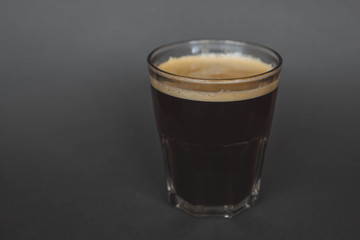 large transparent glass filled with of aromatic filter americano coffee photographed on the isolated gray background picture for the menu.