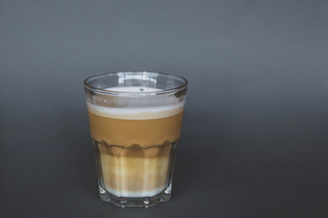 large transparent glass filled with of aromatic coffee photographed on the isolated gray background picture for the menu.