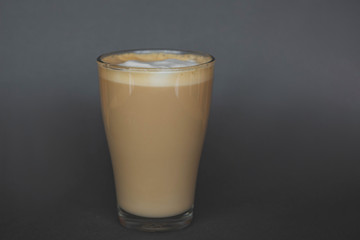 large transparent glass filled with of aromatic coffee photographed on the isolated gray background picture for the menu.