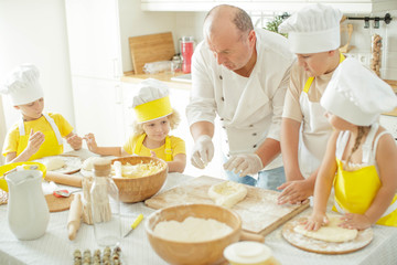 Children cook in the kitchen. Happy child learns to cook in the kitchen delicious chef chef. 