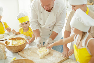 Children cook in the kitchen. Happy child learns to cook in the kitchen delicious chef chef. 