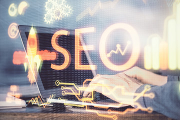 Double exposure of seo icon with man working on computer on background. Concept of search engine...