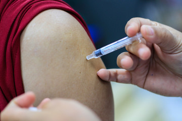 Nurse  making a vaccination to the shoulder of patient