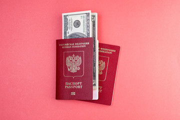 two Russian passports on the background of one of the passports inserted money