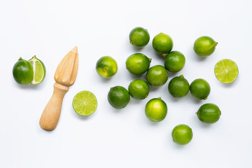 Fresh limes and wooden juicer on white background.