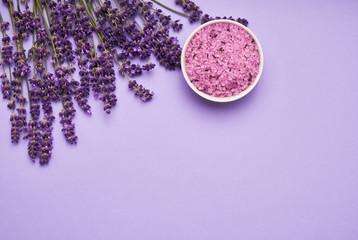 Obraz na płótnie Canvas Lavender SPA. Lavender flowers and bath salt in bowl on purple background. Copy space, top view. SPA concept