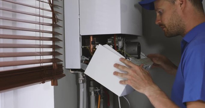 maintenance and repair service engineer working with house gas heating boiler
