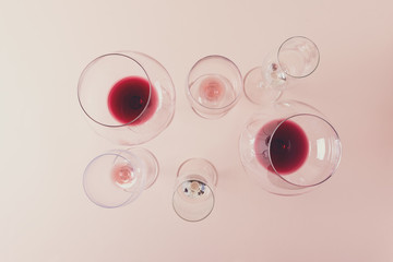 Assorted wineglasses with red, rose and white wine stay on pink background. Wine degustation...