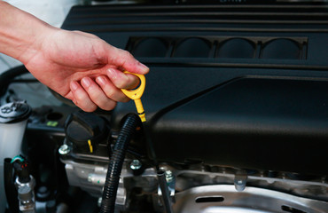 Fototapeta na wymiar Hand pulling checker for check oil engine of car 
