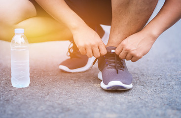 Man tighten shoelaces for running in healthy lifestyle 