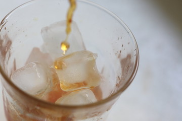 Fototapeta na wymiar 氷の入ったグラスにお茶を注ぐ