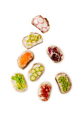 Toast sandwiches with avocado, tomatoes and olives. Isolated on white background. Top view