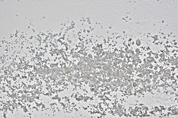The texture of dried paint that will climb off the wall. Background of old wall with traces of rust. Peeling paint with dirty marks on the concrete.