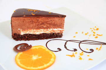 Piece of chocolate cake with decoration on white plate