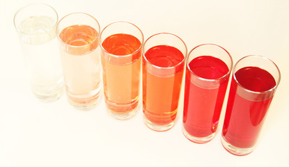 Five glasses of red liquid on white background, São Paulo, Brazil