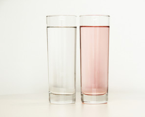 Two glasses of rose and transparent liquid on white background, São Paulo, Brazil