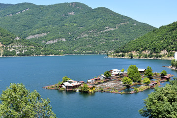 Fototapeta premium Floating fish farm in the blue waters of Vacha Lake, Rhodope Mountains, Bulgaria