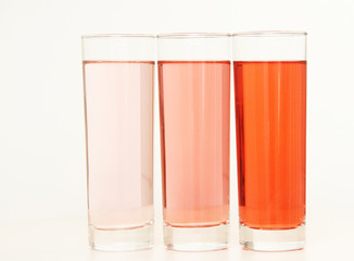 Three glasses of red and transparent liquid on white background, São Paulo, Brazil