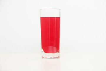 One glass of red  liquid on white background, São Paulo, Brazil