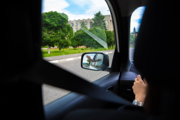 car travel concept view of hand in rear mirror
