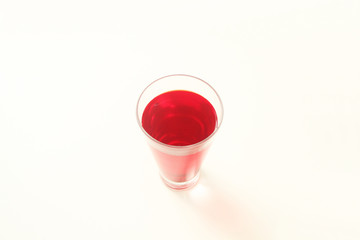 One glass of red  liquid on white background, São Paulo, Brazil