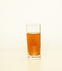 One glass of yellow and transparent liquid on white background, São Paulo, Brazil