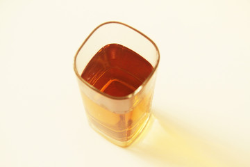 One glass of yellow and transparent liquid on white background, São Paulo, Brazil