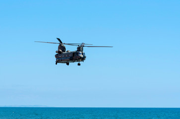 Fototapeta na wymiar Sidmouth, Devon, England, July 2019. A RAF Chinook heavy lift helicopter flying along the south west coast at Sidmouth, Devon, UK