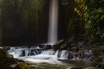 Waterfall landscape. Beautiful hidden Sumampan waterfall in tropical rainforest in Bali near Ubud. Slow shutter speed, motion photography.