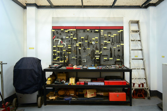the metal shelf in storage room with many mechanic  tools ,labels ,staircase  and boxes  at repair shop