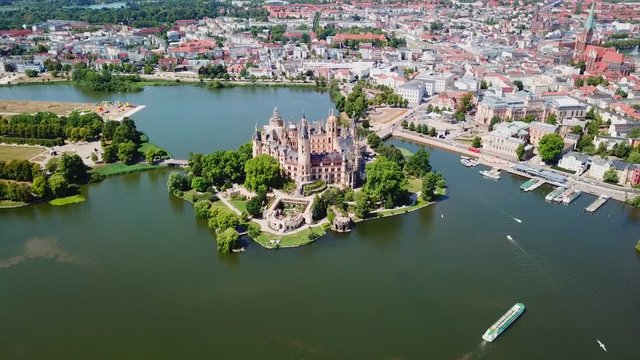 Aerial, reverse, drone shot, tilting away from the Schwerin Castle and the city, on a sunny summer day, in Germany
