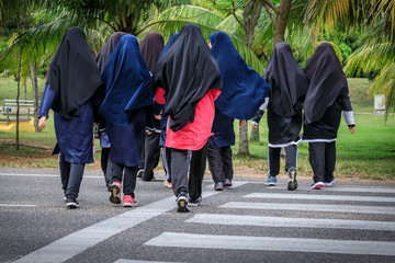 Muslimische Mädchengruppe geht über die Straße